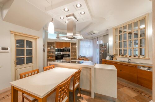 Open kitchen with counter and chairs near cupboards