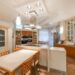 Open kitchen with counter and chairs near cupboards